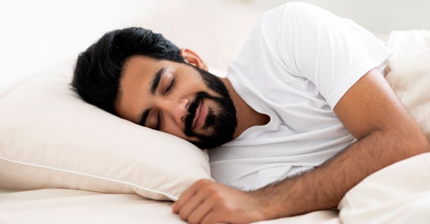 Mies nukkuu mukavasti sängyssään