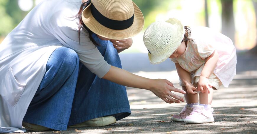 äiti hoitaa lapsen asfaltti-ihottumaa kesällä