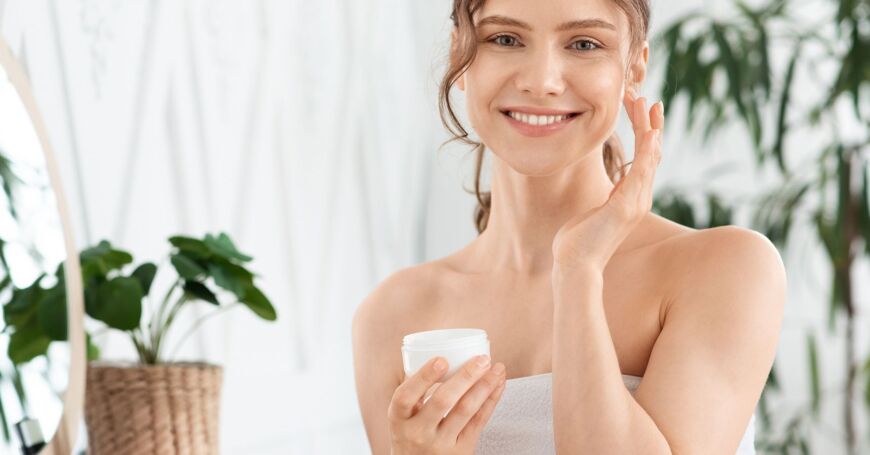 Nainen levittää luonnonkosmetiikan kosteusvoidetta kuivalle iholle.
