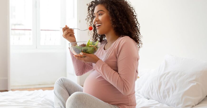 Raskaana oleva nainen syö monipuolisesti ruokaa ja käyttää raskausvitamiineja tärkeiden vitamiinien riittävän saannin varmistamiseksi.