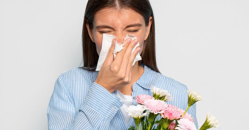 Siitepölyallergian oireista ja heinänuhasta kärsivä aivastelee ja niistää nenää.