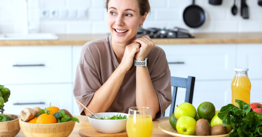 nainen nauttii C-vitamiinia sitrushedelmien ja tuorepuristetun mehun muodossa